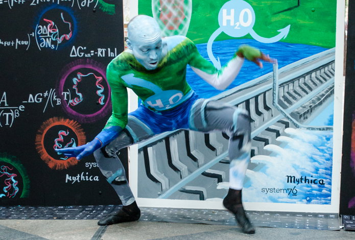 Engineering dancer crouched down dancing in front of the panels