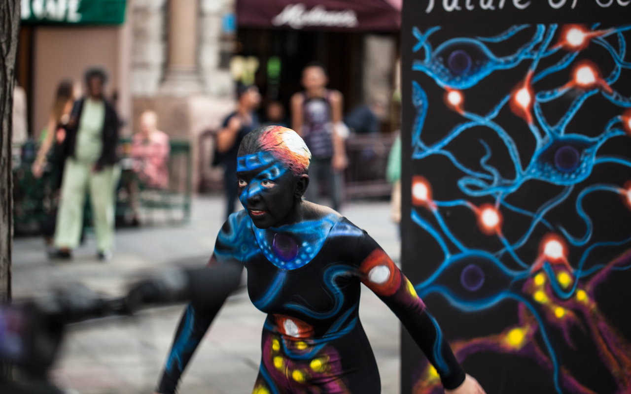 Action shot of the Science dancer in motion in front of her panel