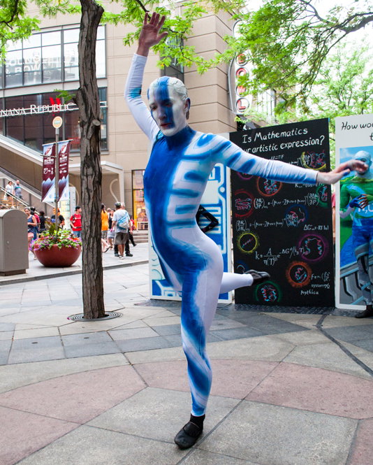 Technology dancer in Arabesque in the street in front of the panels